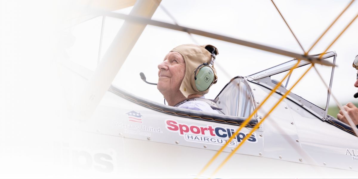 elderly veteran looking blissfully into the beyond while sitting in the cockpit of a 1942 bi-plane 