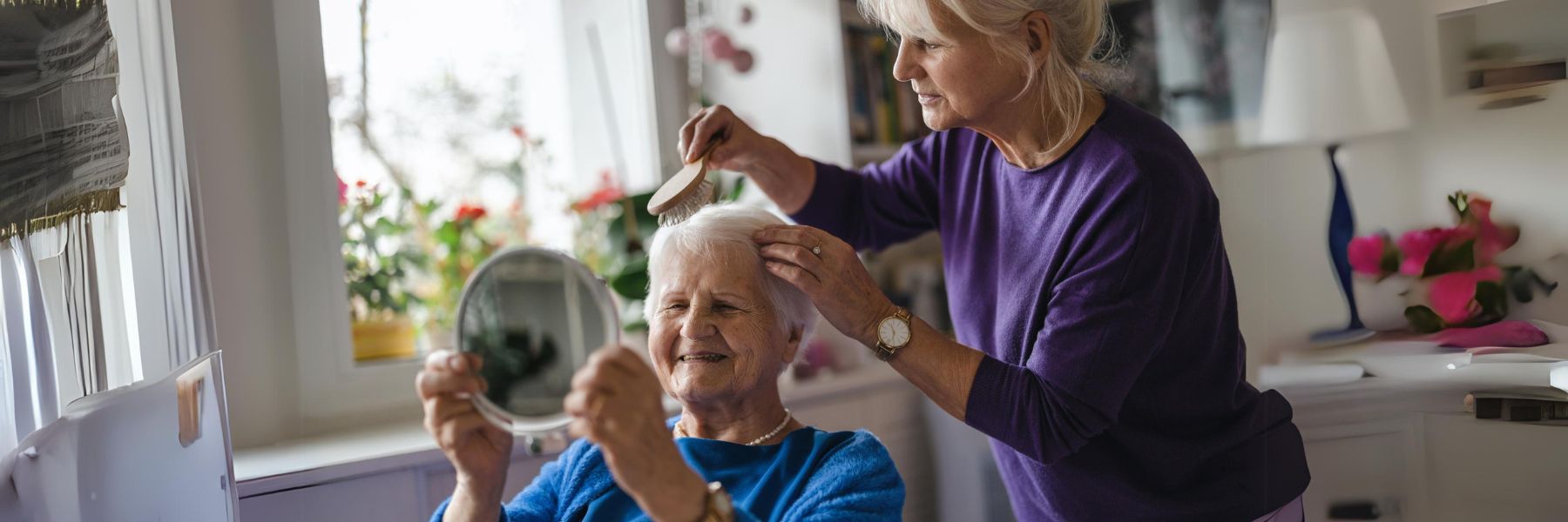 a woman caring for her seniuor adult mother by brushing her hair