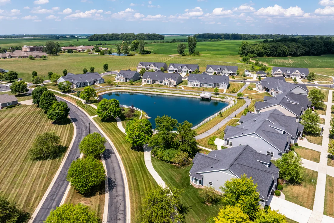 Aerial exterior view of independent living villas around a pond at Browning Masonic Community