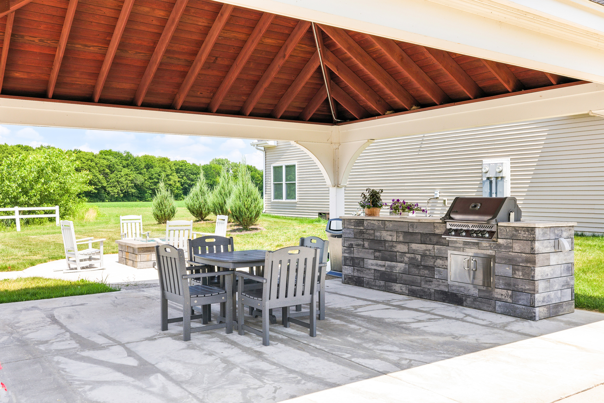 Outdoor patio with table and chairs and a grill