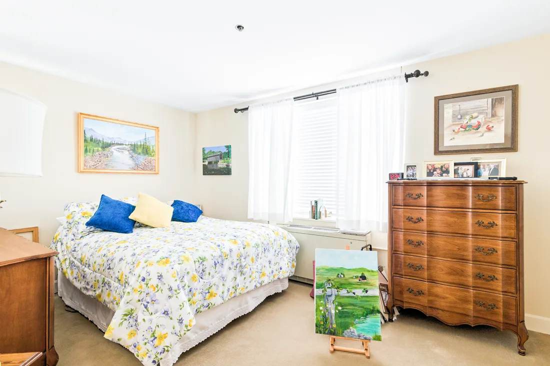 Bedroom with large window and dresser in an independent living residence