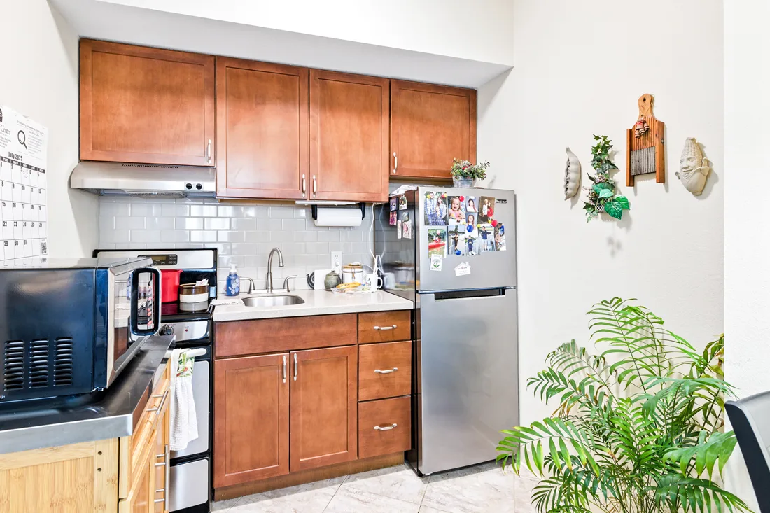 Small kitchen apartment with cabinets, a refrigerator, sink, stove, and microwave