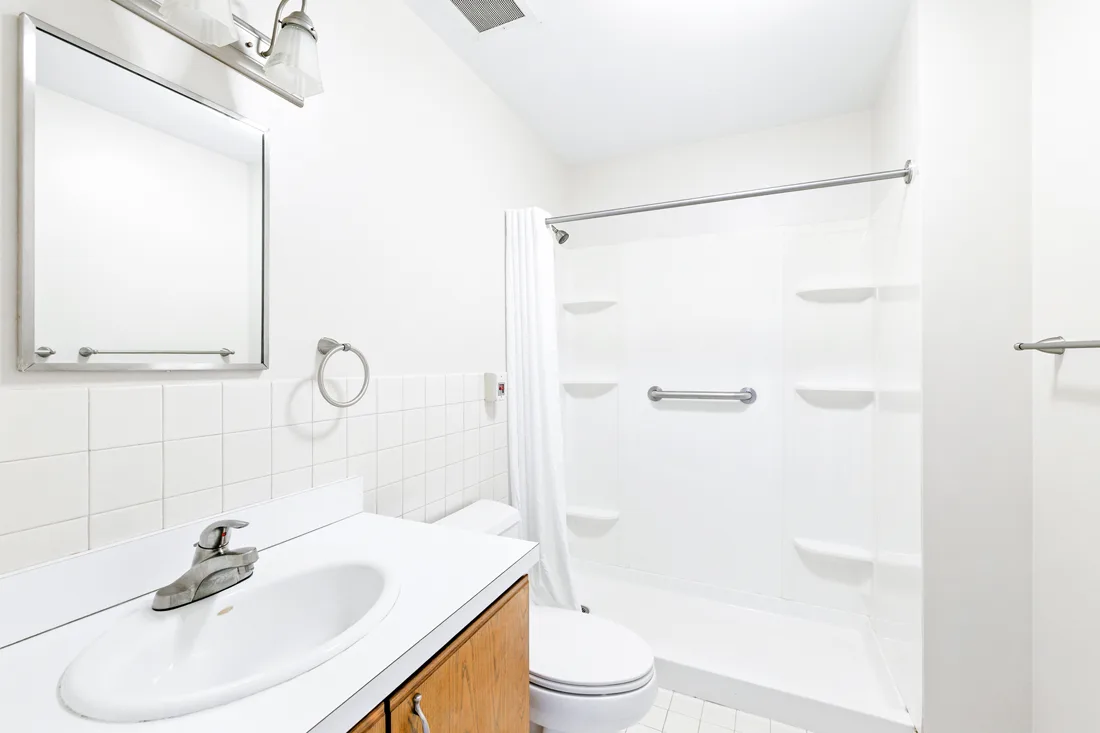 Bathroom with a shower, toilet, sink, and a mirror