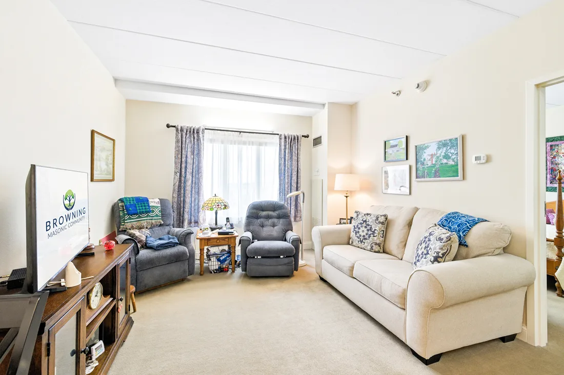 Living room with a couch, a television, and chairs