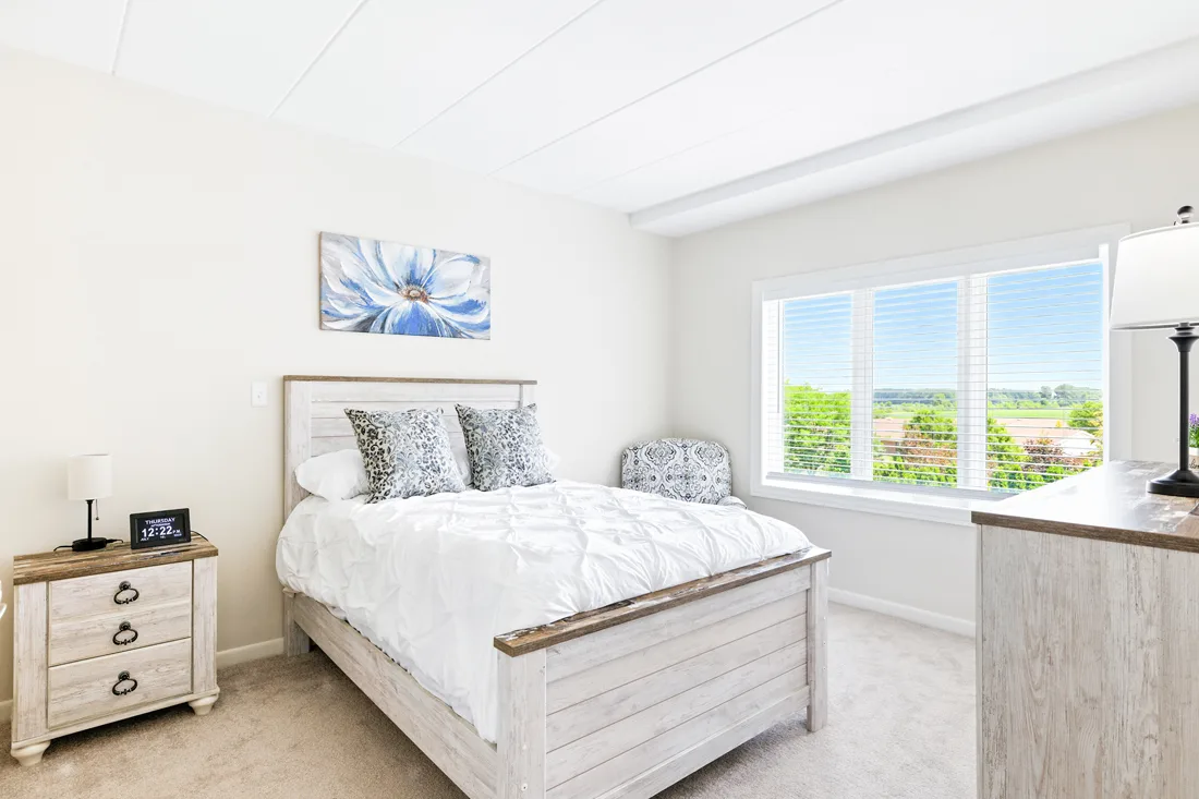 Bedroom with large window, nightstand, chair, and dresser