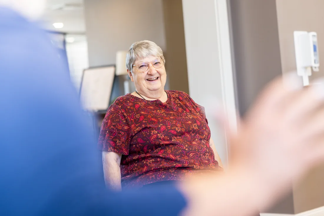 Older adult female exercises while seated in a fitness room