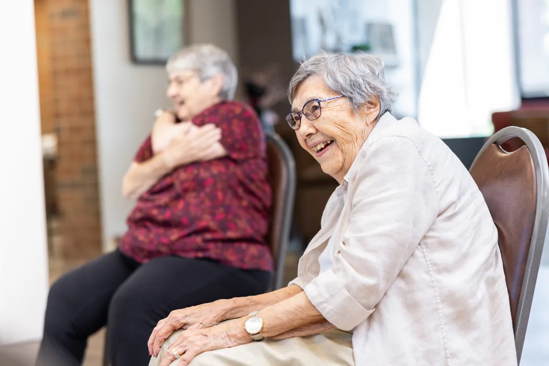 Older adult females exercise while seated in a fitness room
