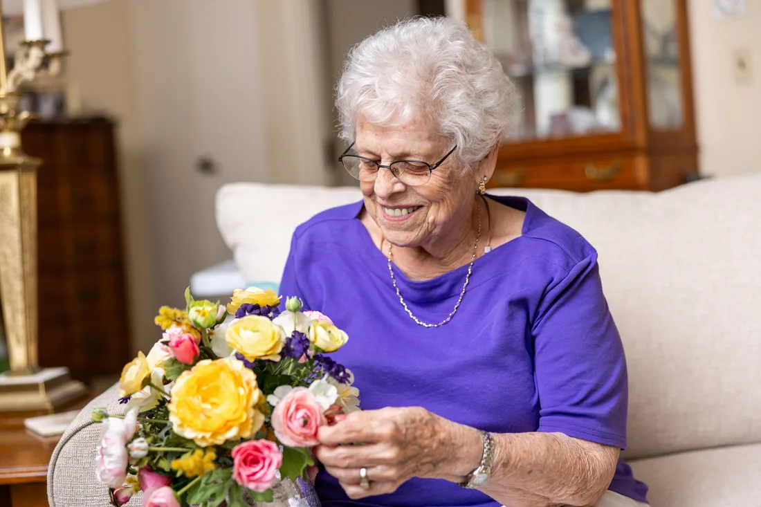 Older adult female holding a bouquet of flowers