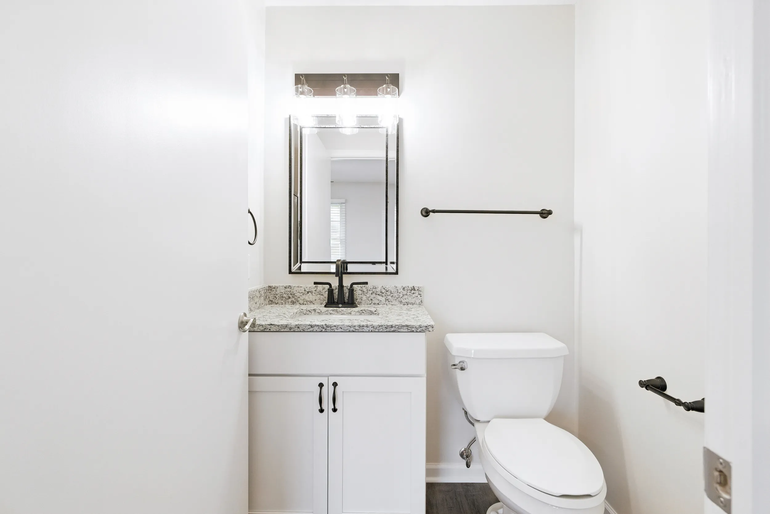 Half bathroom with a toilet, sink, and mirror