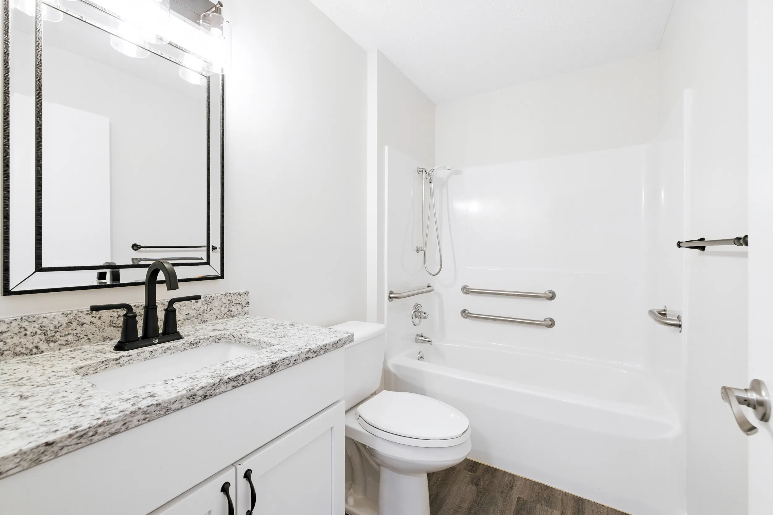 Bathroom with a sink, mirror, toilet, and tub/shower combo