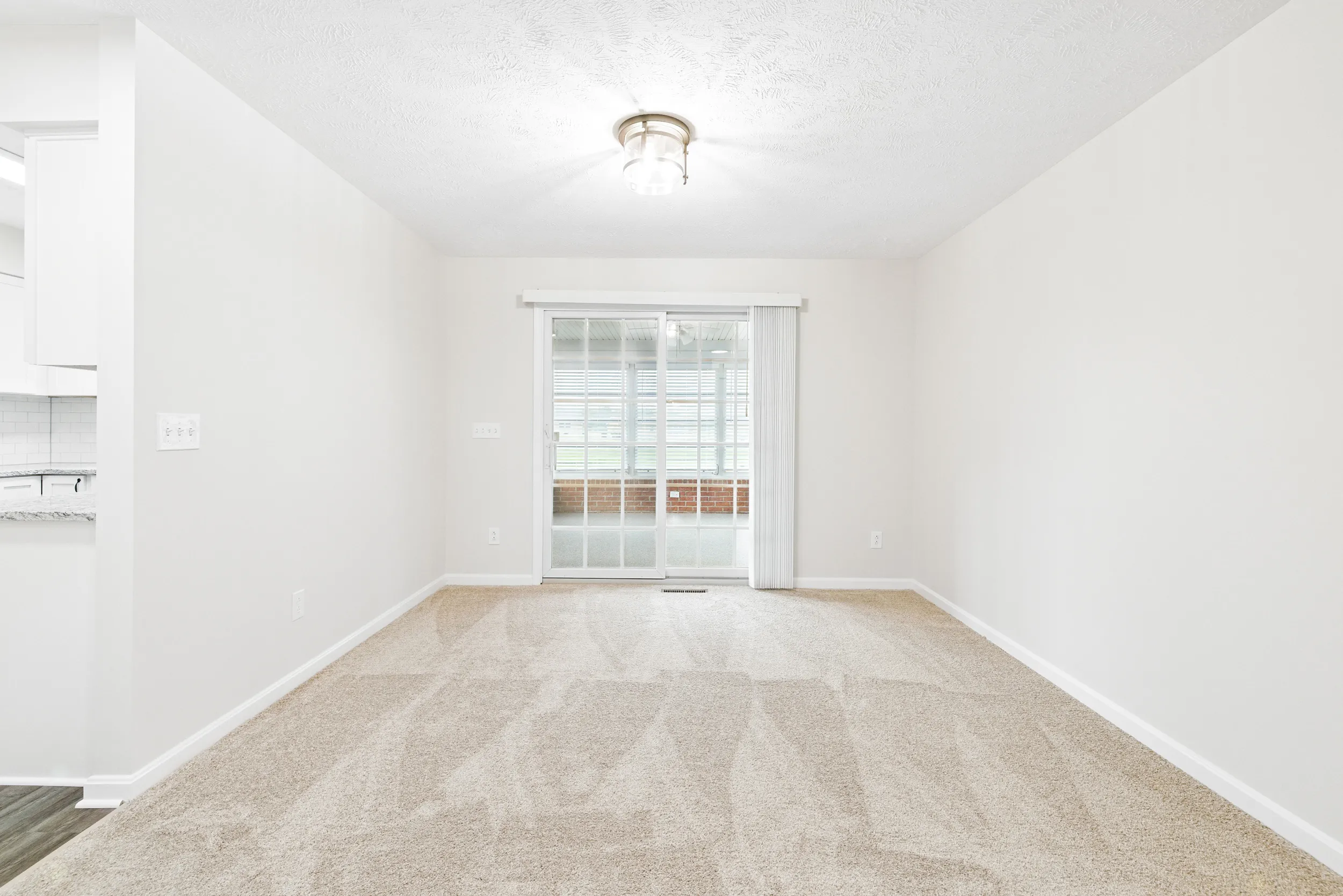 Living area leading to sliding sunroom doors
