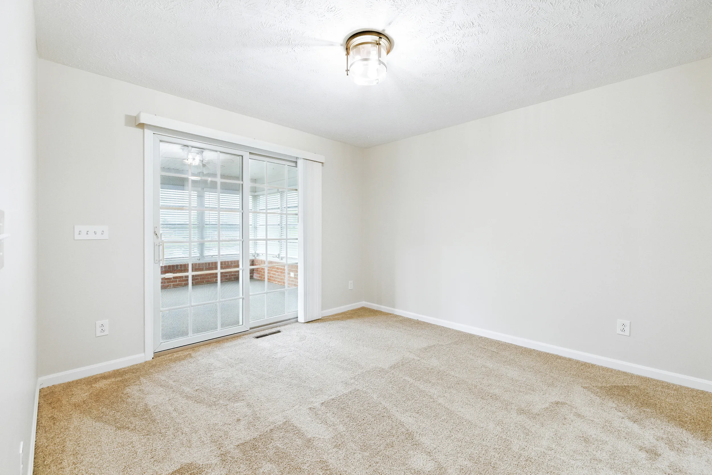 Living area leading to sliding sunroom doors