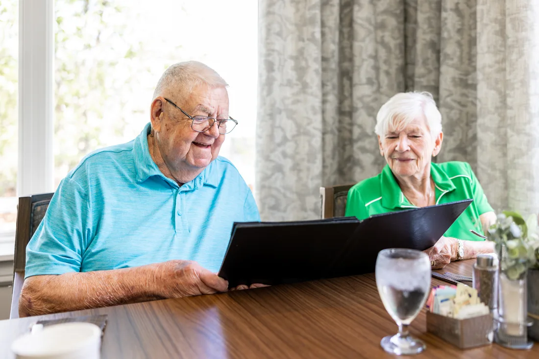 Older adult male and female looking at a menu