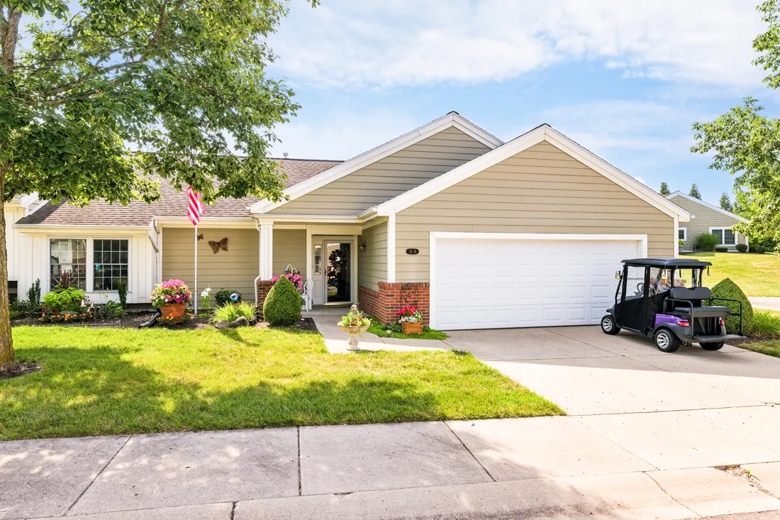 Exterior view of home with an attached garage and golf cart in the driveway