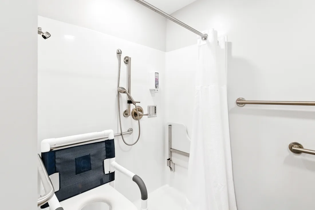 Accessible shower with shower chair and grab bars