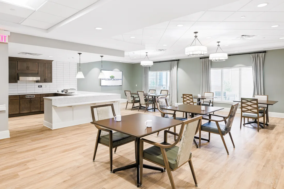 Dining room with tables and chairs and an open kitchen