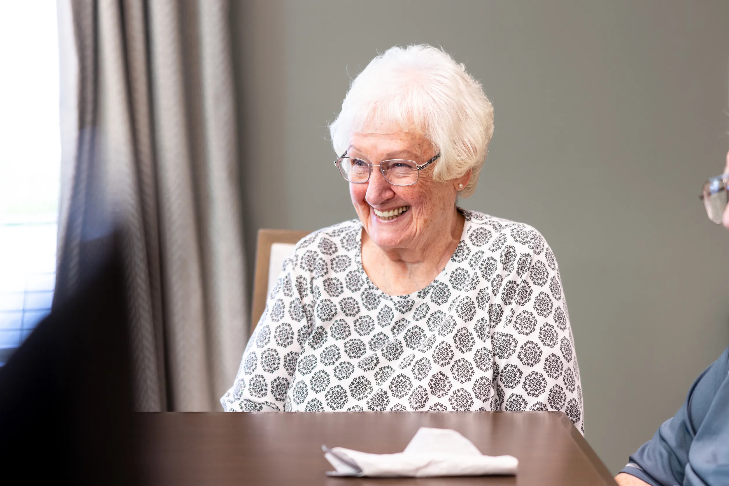 Female resident smiling in the dining room