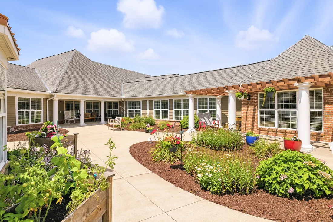 Exterior view of courtyard with flowers, plants, and raised garden boxes
