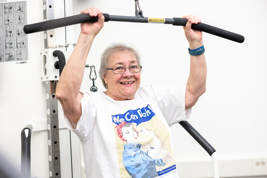 Older adult using weight machine to exercise