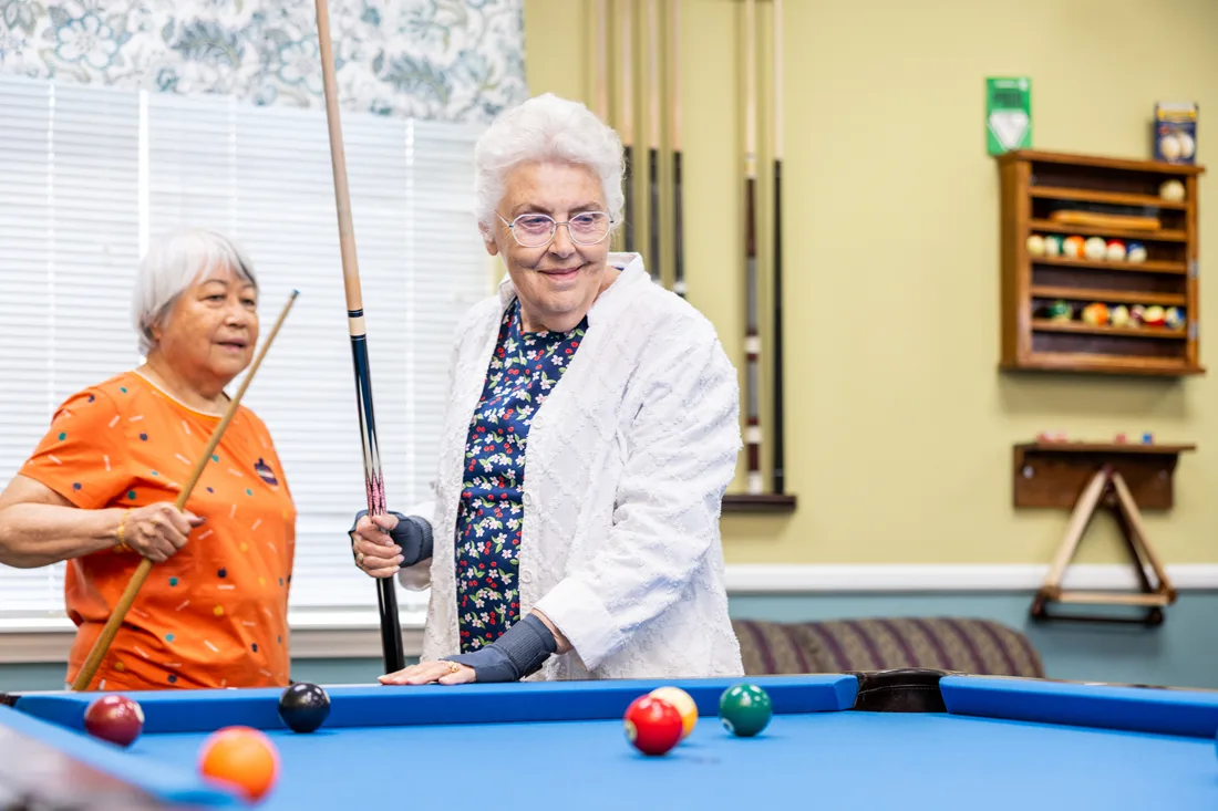 Older adult females play pool