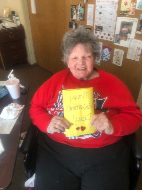 Resident holds up handmade Valentine cards
