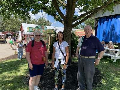Adults standing outdoors at a fair
