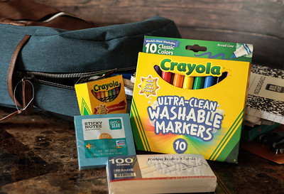 School supplies, including crayons, markers, notecards, and sticky notes