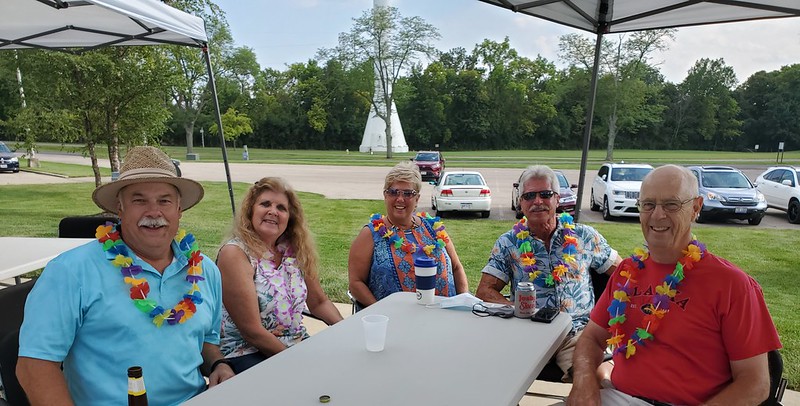Small group wearing leis sits together outside