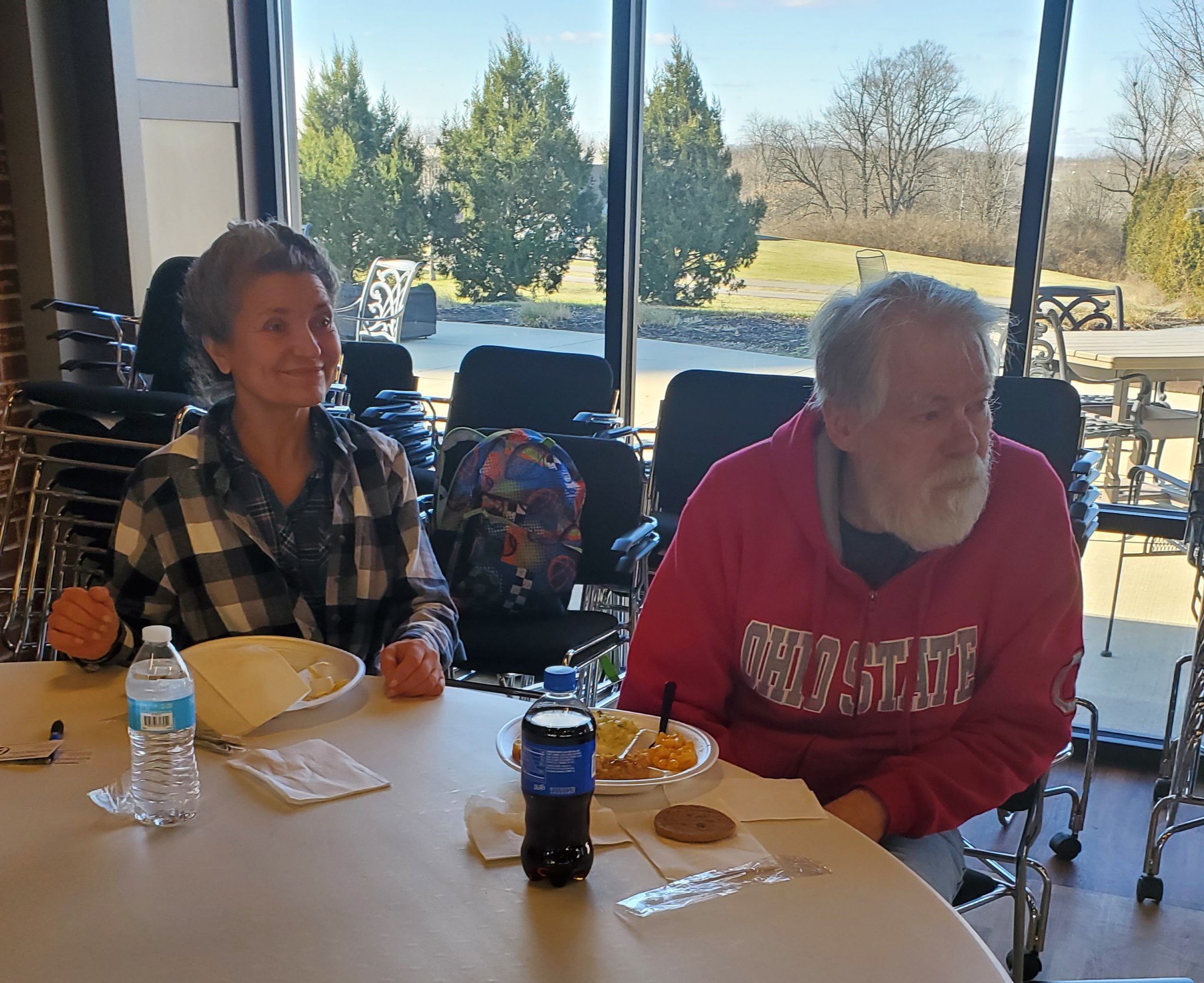 Residents and guests eating together and listening to a guest speaker