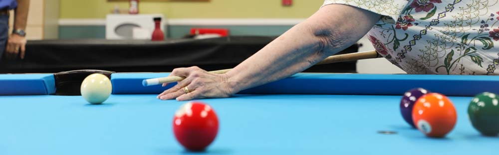 Older adult playing pool