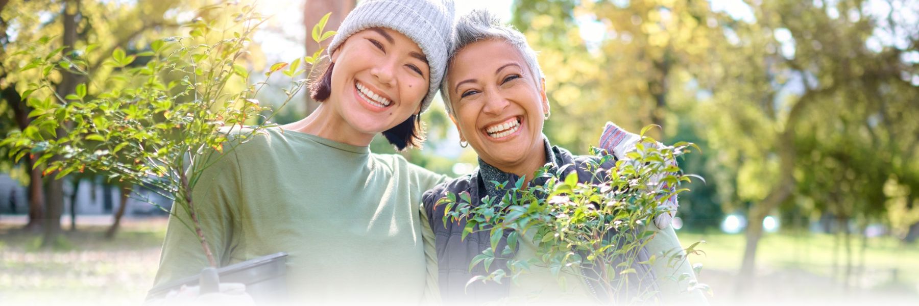 Two women volunteering with smiles and plants