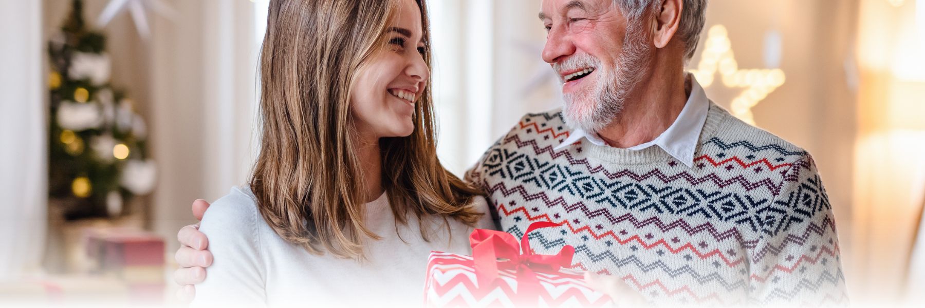 Female stands and smiles near older adult male