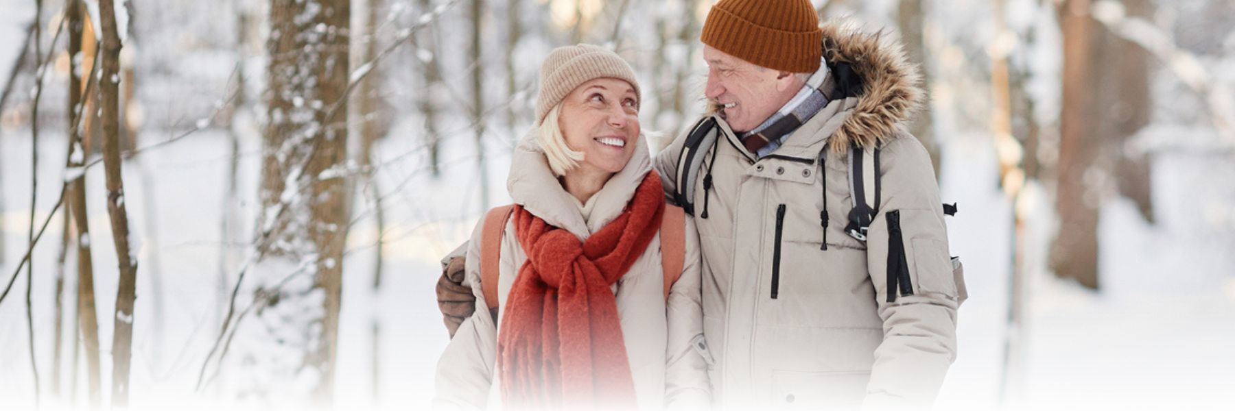 Older adult couple walking together outdoors on a snowy winter day