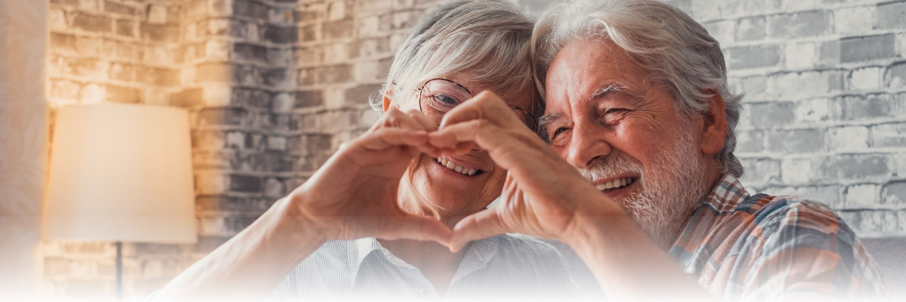Older adult couple making heart with hands, focusing on cardiovascular health