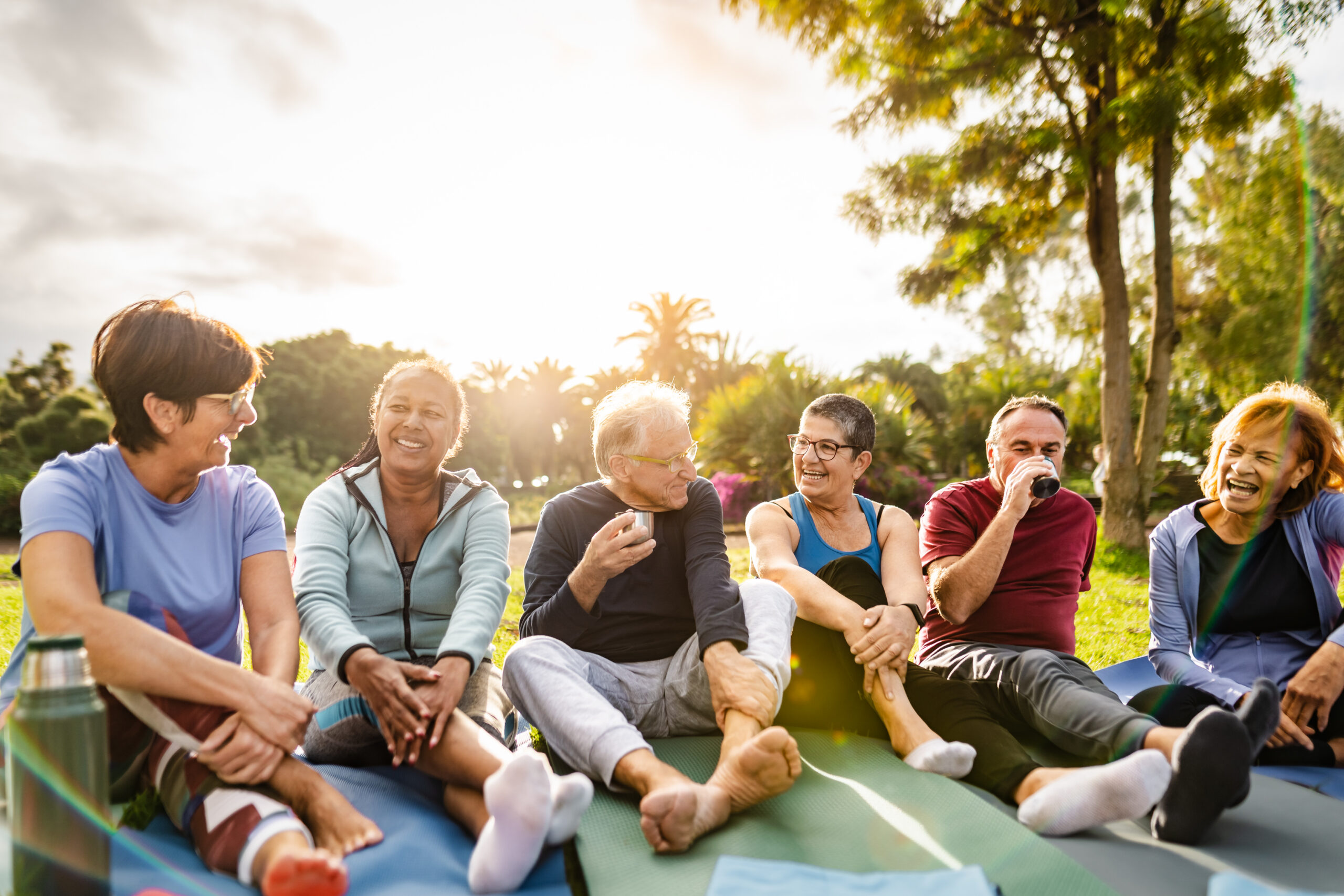 Happy multiracial senior friends talking after workout activities in a park