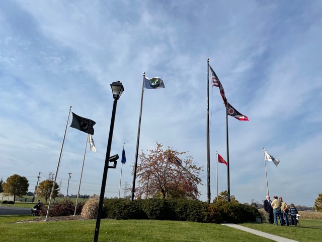 View of several military and U.S. flags flying outside the community