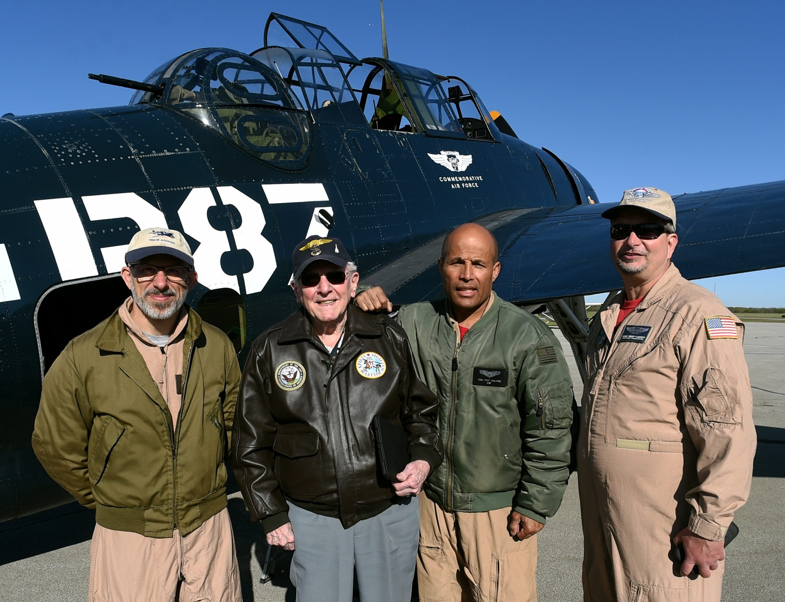 View of pilots with male resident in front of old airplane