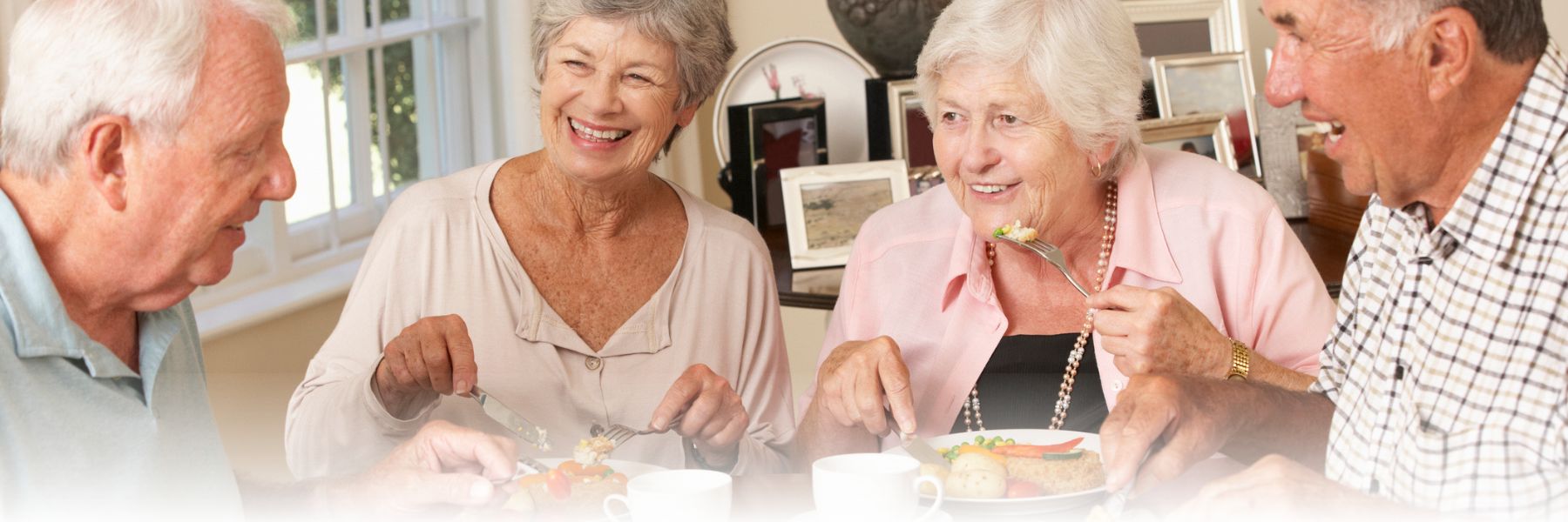 Group of older adults eating and socializing with connection