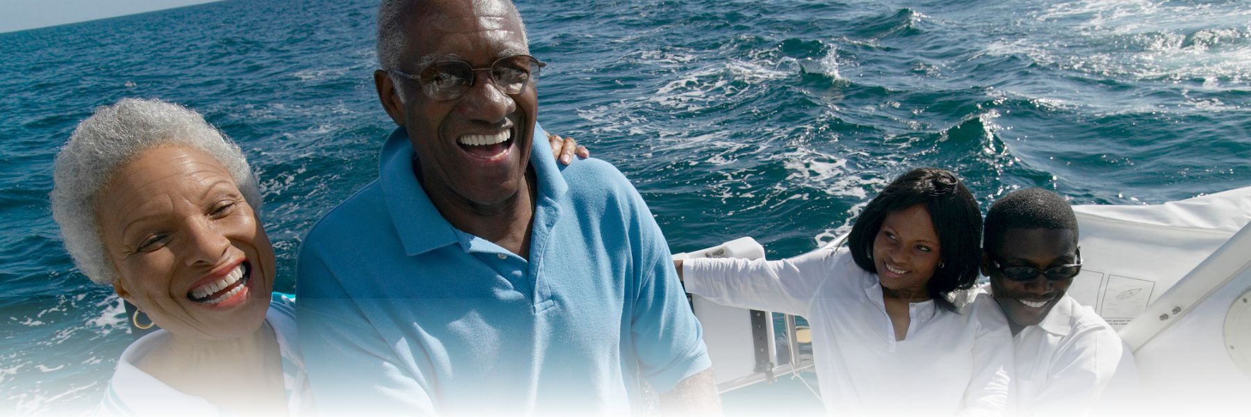 senior adult African american couple with family on a boat enjoying the Summer Vacation for Older Adults
