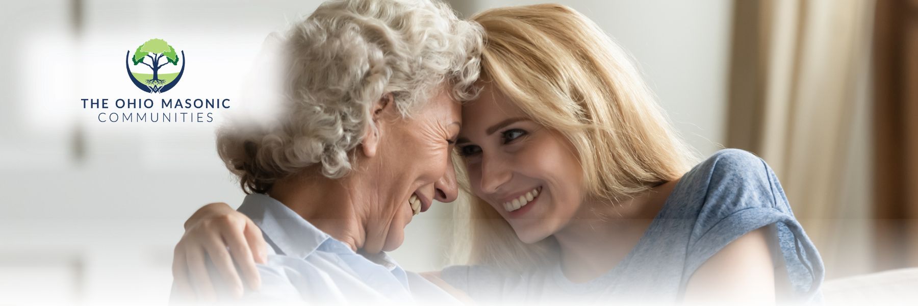 Older adult female smiling and placing her forehead on young adult female's forehead
