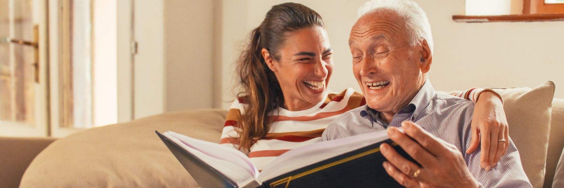 Older adult man and loved one reading and laughing