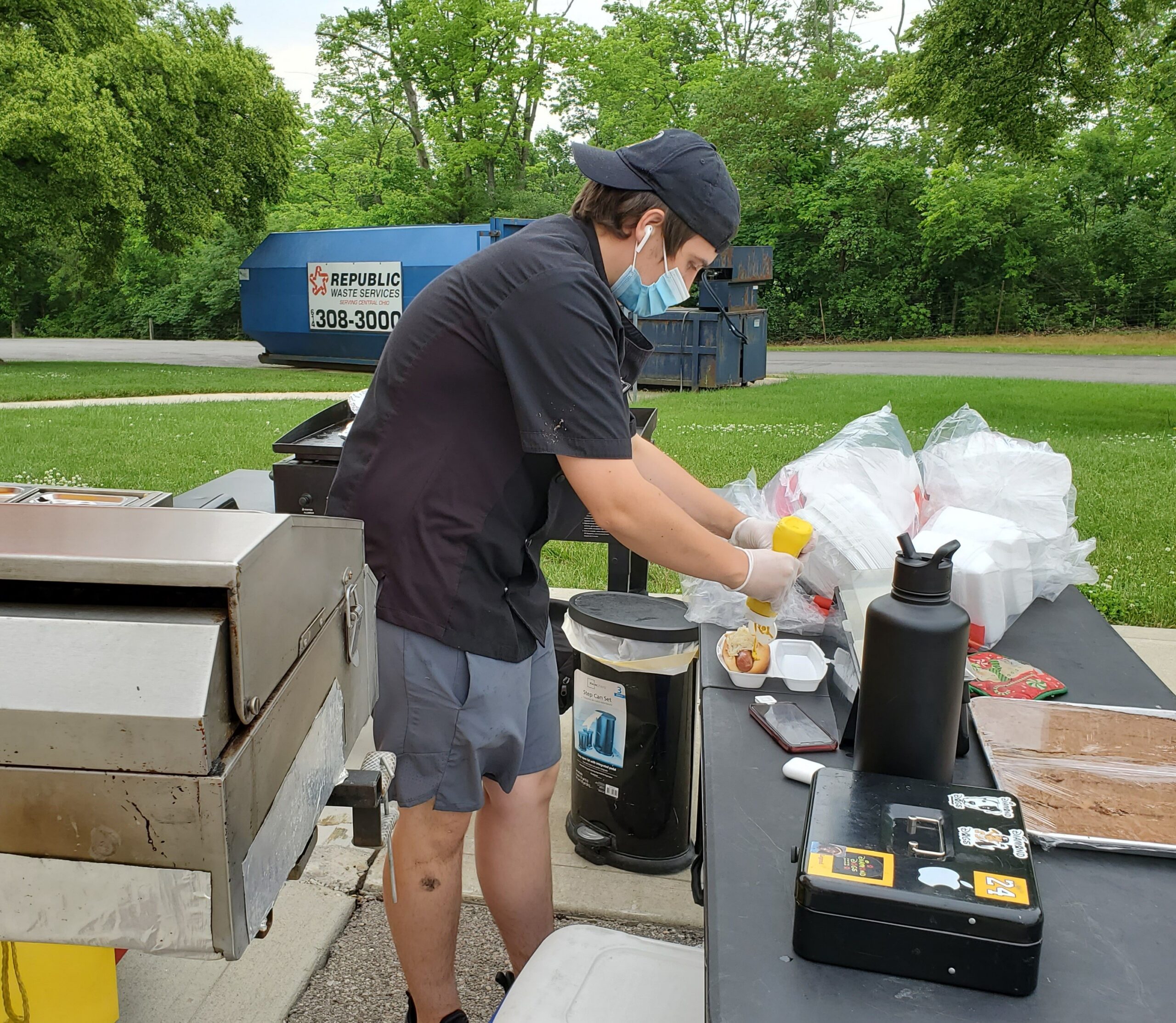 Team member preparing hot dogs outside