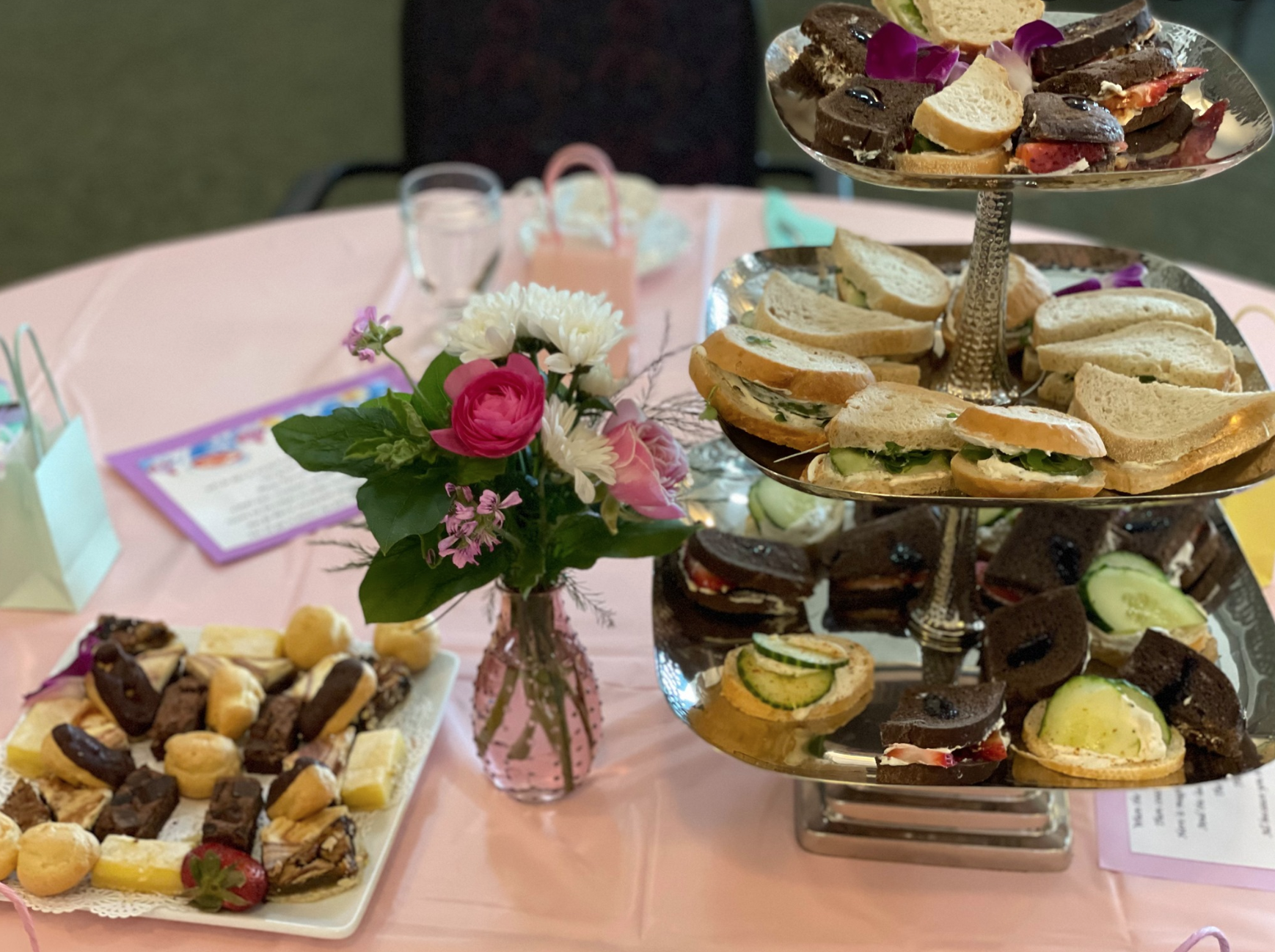 Close-up view of table centerpiece of fresh flowers and set with a variety of desserts and snacks