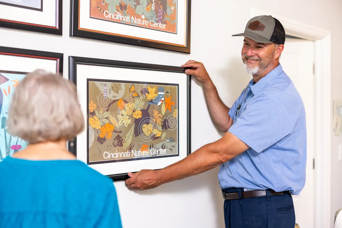Team member hanging a picture for a resident