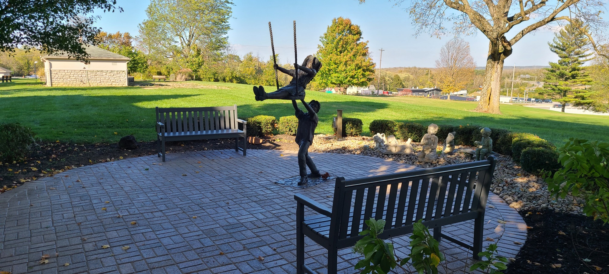Statue of a boy pushing a girl on a swing in the park