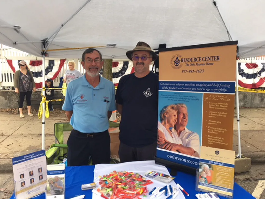 Resource Center team members at a booth with a marketing display advertising their services