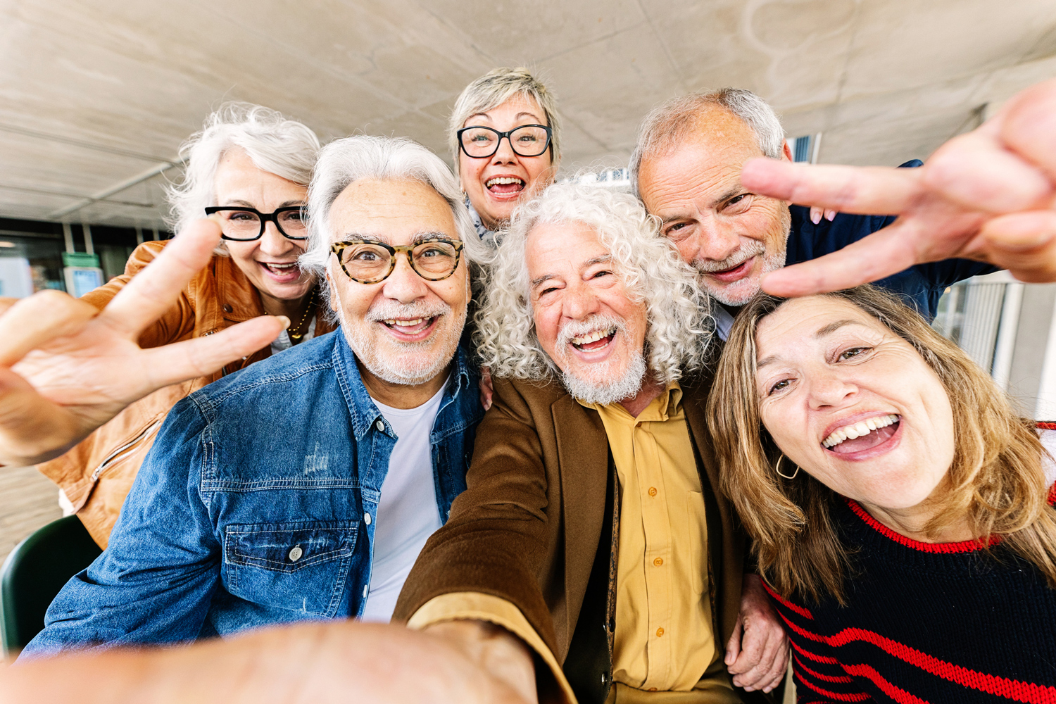 Group of older adults smiling and giving the peace sign