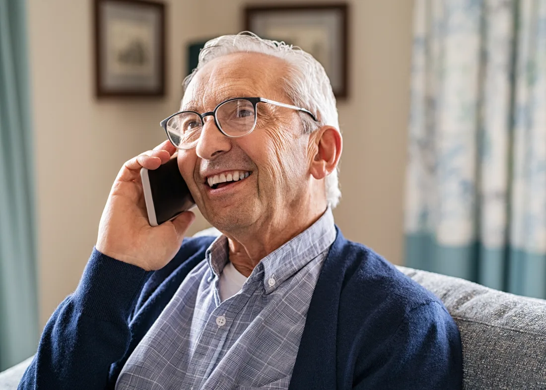 Older adult male smiling and talking on his cell phone