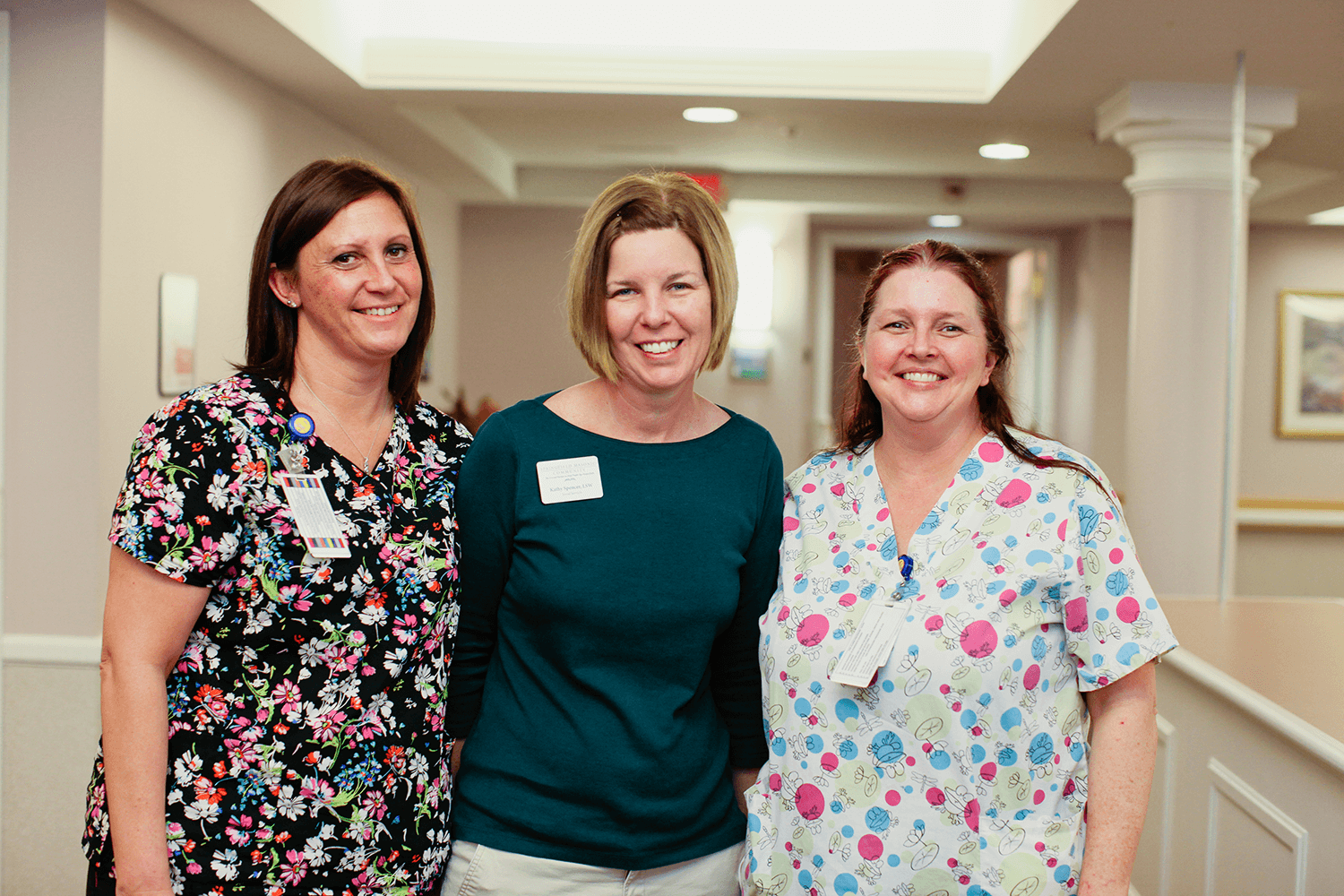 Three female team members stand together for a picture