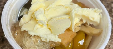 Close up view of peach cobbler with ice cream